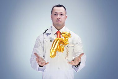 Doctor with stethoscope and golden penis on the hands in a hospital. High resolution.