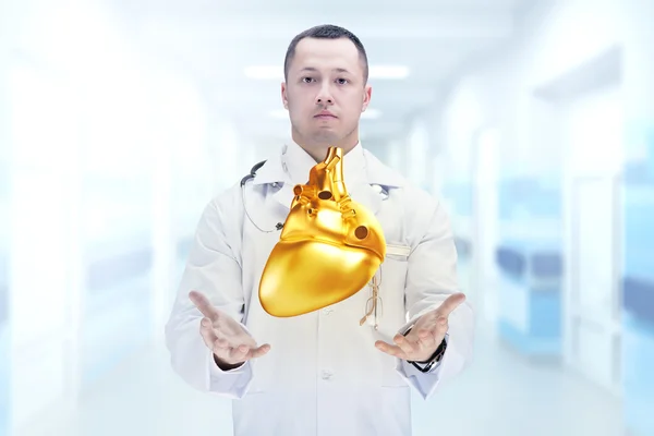 Doutor com estetoscópio e coração dourado nas mãos em um hospital. Alta resolução . — Fotografia de Stock