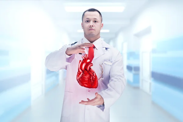 Доктор со стетоскопом и сердцем на руках в больнице. Высокое разрешение . — стоковое фото