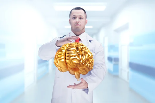 Doctor con estetoscopio y cerebro dorado en las manos. Alta resolución . — Foto de Stock