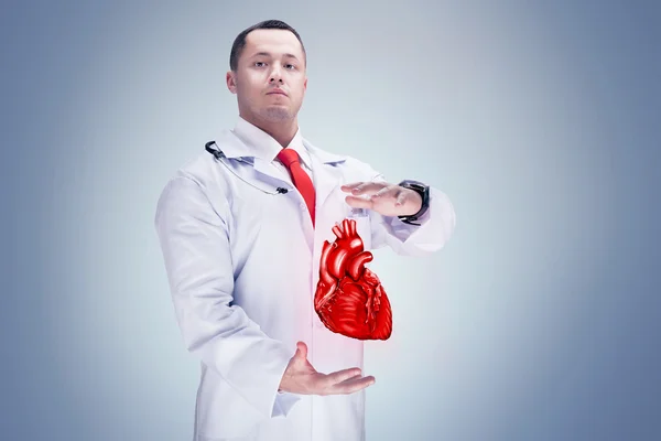 Doctor with stethoscope and heart on the hands in a hospital. High resolution. — Stock Photo, Image