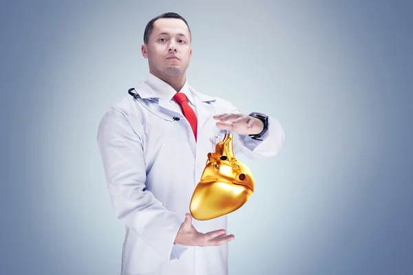 Доктор со стетоскопом и золотым сердцем на руках. Высокое разрешение . — стоковое фото