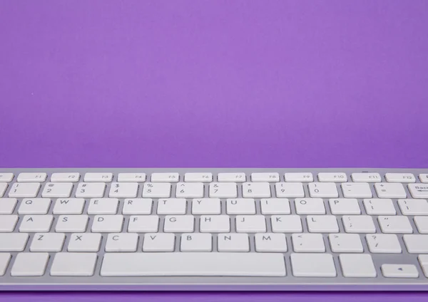 Počítačová klávesnice na fialové pozadí — Stock fotografie