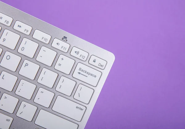 Tastiera per computer su sfondo viola — Foto Stock