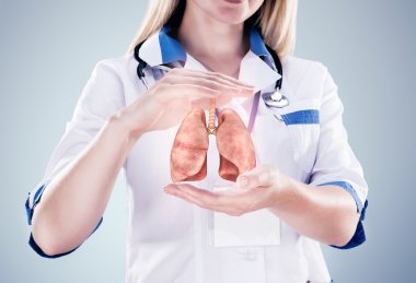 Elinde stetoskop ve akciğerler ilerde doktor. gri arka plan.