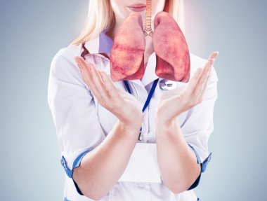 Elinde stetoskop ve akciğerler ilerde doktor. gri arka plan.