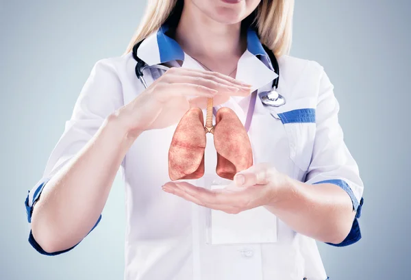 Arzt mit Stethoskop und Lungen an den Händen. grauer Hintergrund. — Stockfoto