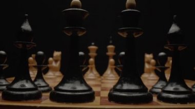 Yakın plan satranç oyunu. Satranç tahtasındaki oyundan önce hazırlanan tahta satranç taşları. Kamera satranç tahtası boyunca hareket eder. Yüksek kalite 4k görüntü