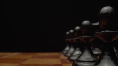 Yakın plan satranç oyunu. Satranç tahtasındaki oyundan önce hazırlanan tahta satranç taşları. Kamera satranç tahtası boyunca hareket eder. Yüksek kalite 4k görüntü