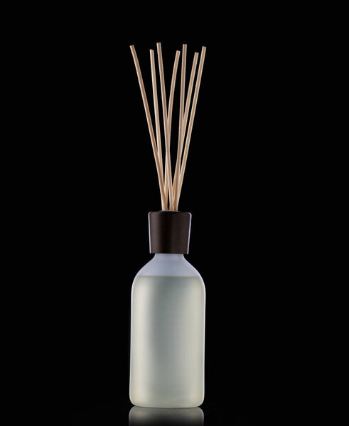 Aroma sticks in glass bottle isolated on black background. Aroma diffuser. Home fragrance.
