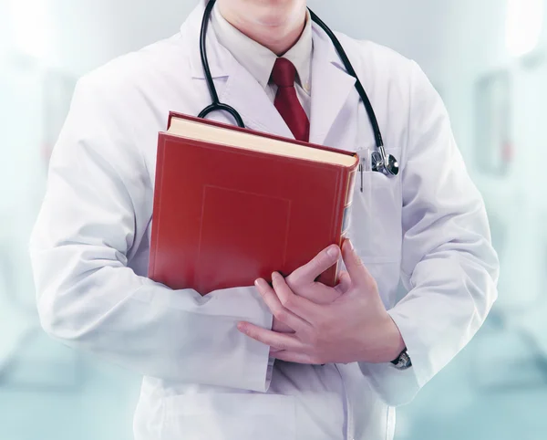 Médecin avec stéthoscope et livre dans un hôpital — Photo