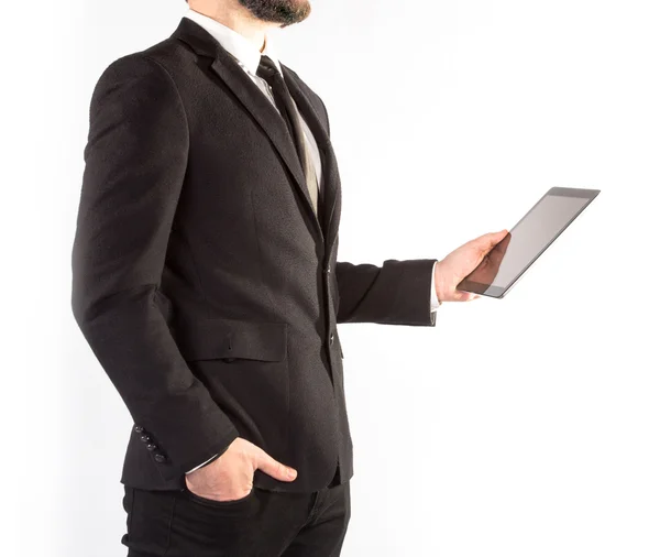 Hipster man i klassisk kostym isolerad på en vit bakgrund med en tablett i hand — Stockfoto