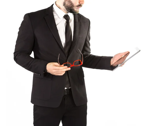 Hipster homme en costume classique isolé sur fond blanc avec une tablette à la main . — Photo