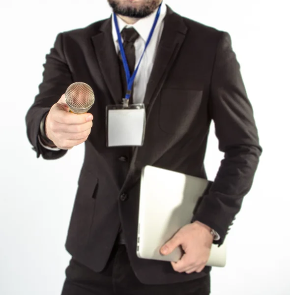 Hipster hombre en un traje clásico aislado sobre un fondo blanco con un cuaderno y micrófono . Fotos de stock
