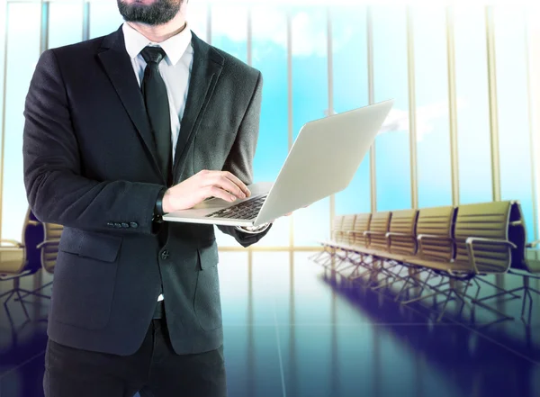 Businessman with digital notebook on blurred background airport . — Stock Photo, Image