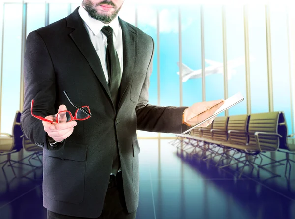 Бізнесмен з цифровим планшетом на розмитому фоні аеропорту . — стокове фото