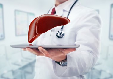 Doktor stetoskop ve karaciğer hastanede elinde tablet ile.