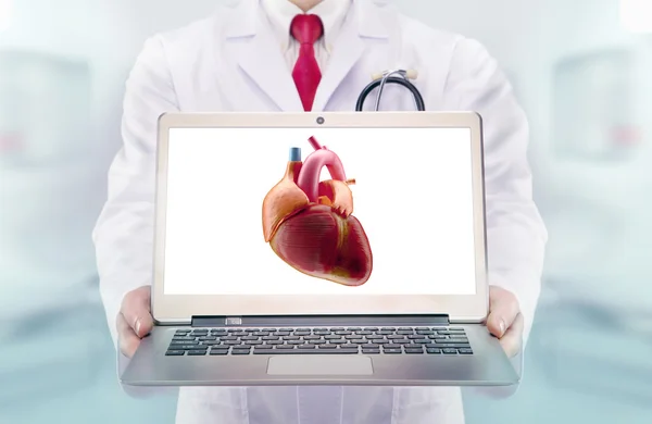 Γιατρός με το στηθοσκόπιο σε ένα νοσοκομείο. Καρδιά στην laptop οθόνη — Φωτογραφία Αρχείου
