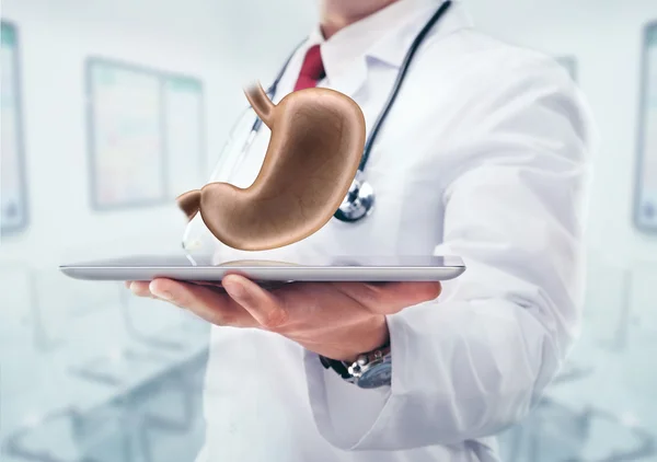 Doktor stetoskop ve mide hastanede elinde tablet ile.