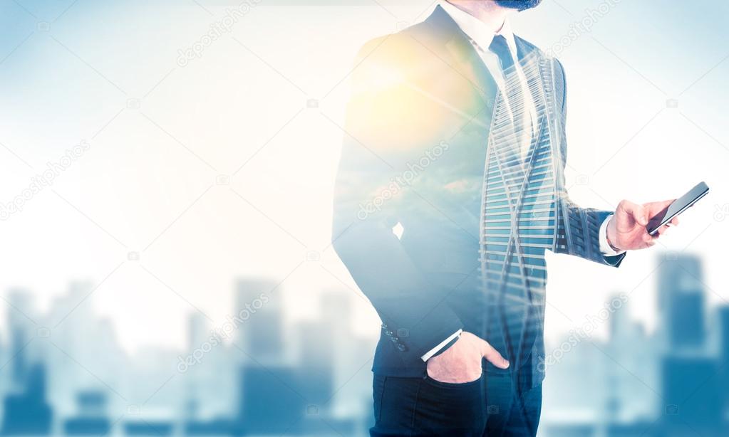 Double exposure of city and business man using mobile phone
