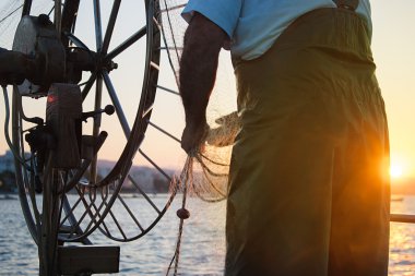 Fisher tekne bir denizde. Eski bir balıkçı elinde