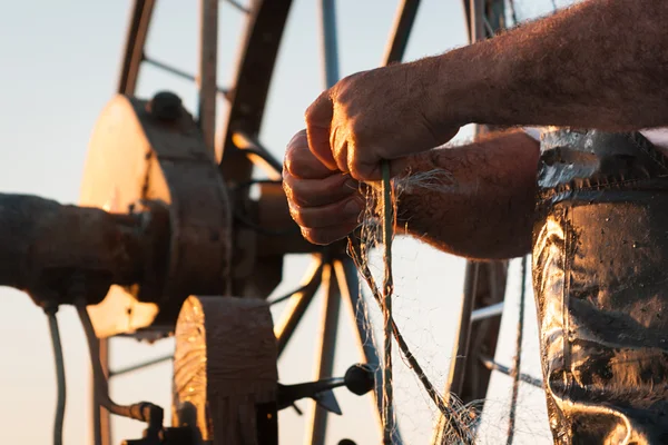 Fisher båt i ett hav. Händerna på en gammal fiskare — Stockfoto