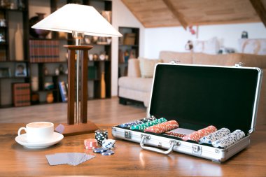 Poker set in a metallic case over wooden table, retro filtered image clipart
