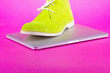 Dizüstü bilgisayar ve cep telefonu pembe bir arka plan üzerinde yeşil Erkek Ayakkabı