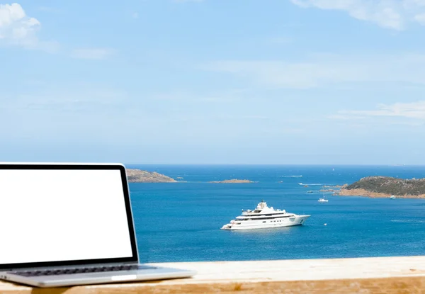 Computador portátil na mesa de madeira com fundo do mar — Fotografia de Stock