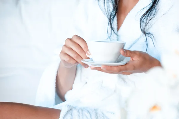 Young woman in a bathrobe with a cup of tea — Stock Photo, Image