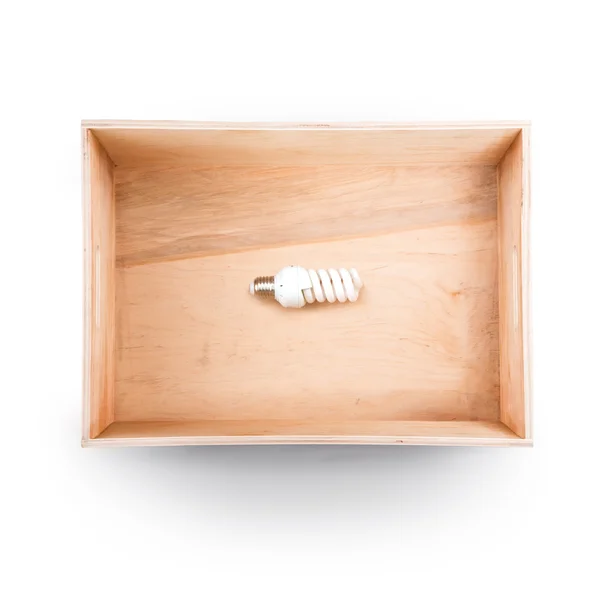 Вид сверху деревянной коробки. Энергосберегающая лампочка внутри . — стоковое фото