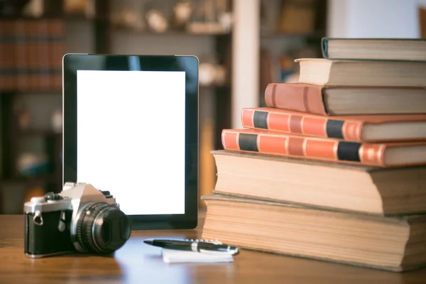 Pila di vecchi libri e tablet su tavolo in legno, immagine filtrata retrò — Foto Stock