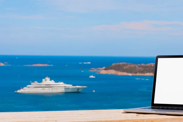 Computador portátil na mesa de madeira com fundo do mar — Fotografia de Stock