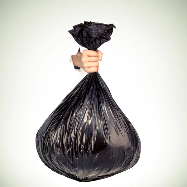 Mano sosteniendo bolsa negra de basura. Captura de estudio . — Foto de Stock