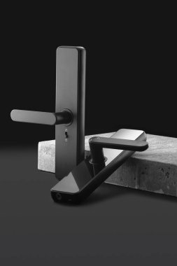 Modern bir tasarım sergilenen sert beton bir yüzeye, şık bir siyah kapı kolu yerleştirilir. Şık çizgiler ve zarif bitiriş modern işçiliğin altını çiziyor.