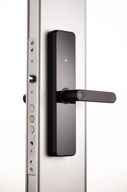 Siyah kapaklı şık bir kapı kolu metalik bir kapıya monte edilmiştir. Sapın modern tasarımı çeşitli iç tasarımları tamamlar ve güvenliği artırır.