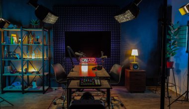 İyi düzenlenmiş bir kayıt stüdyosunda ses ekipmanları, mikrofonlar ve davetkar bir atmosfer için samimi ışıklandırma ile birlikte neon ışıklı bir tabela bulunmaktadır..