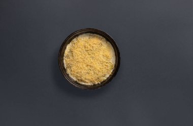 Bol miktarda dilimlenmiş peynirle süslenmiş doyurucu tabaklı bir tabak, siyah bir tabakta duruyor. Bu yemek aile toplantısı ya da özel bir gün için mükemmel..