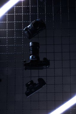 Karanlık bir ortamda birkaç silah bir şebeke duvarına monte edilir. Farklı silah türleri ve bir nesne düzgün bir şekilde sıralanır. Parlak ışıklar ekran etrafında.