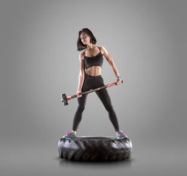 运动年轻女子健身锻炼用锤子上灰色工作室背景 — 图库照片