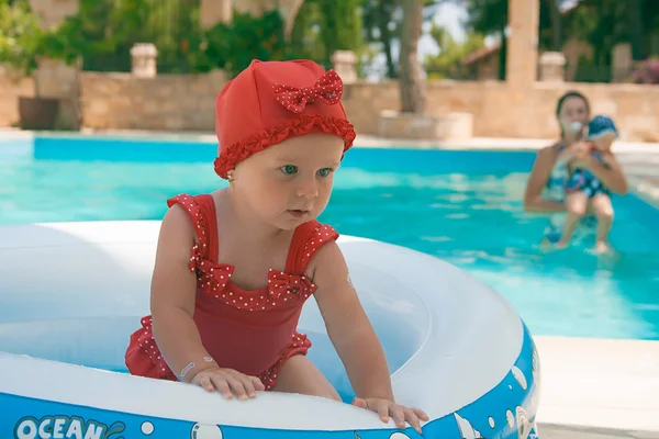 Un niño pequeño y feliz está jugando afuera en una piscina para bebés. — Foto de Stock