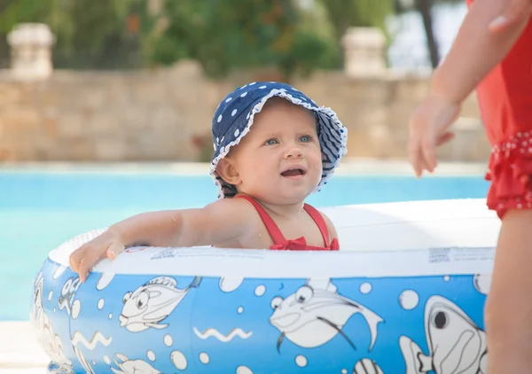 Un niño pequeño y feliz está jugando afuera en una piscina para bebés. — Foto de Stock