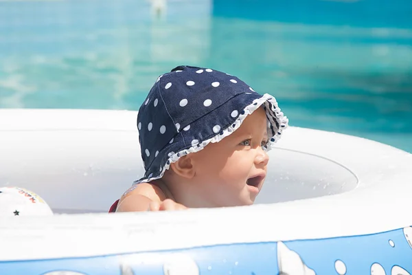 Un niño pequeño y feliz está jugando afuera en una piscina para bebés. — Foto de Stock