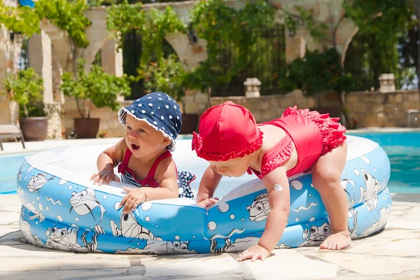 Un niño pequeño y feliz está jugando afuera en una piscina para bebés. — Foto de Stock