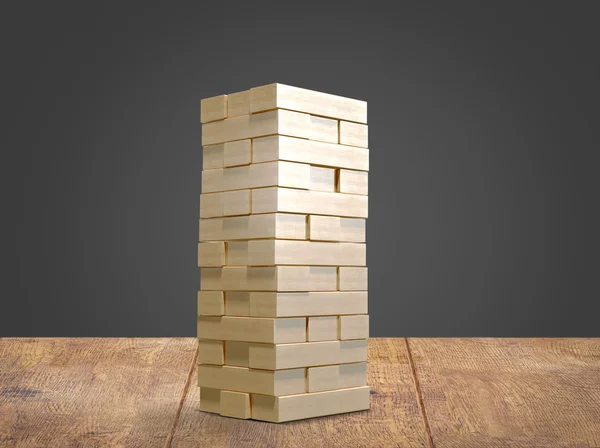 Blokken hout spel jenga op houten vloer zwarte achtergrond. — Stockfoto