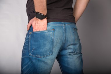Kot pantolon cebinde gri arka plan üzerinde el ile bir genç moda adamın arka cose kadar