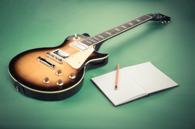 Elektro gitar ile not etmek ve yeşil zemin üzerine eski fotoğraf makinesi