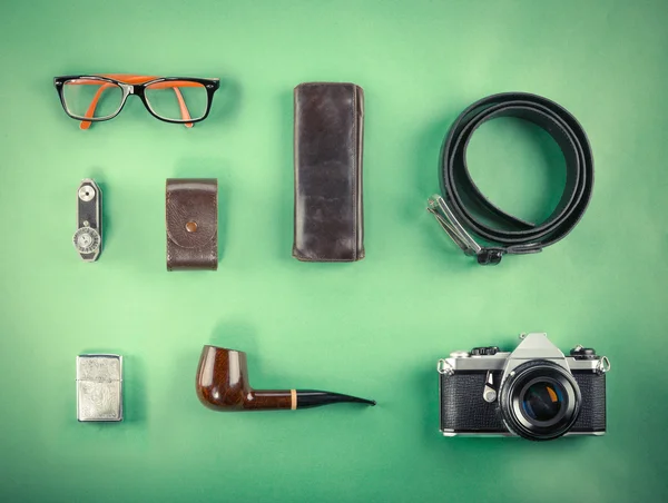 Se burlan de Retro hipster. Portátil, cámara vieja, tableta y pipa de humo sobre fondo verde. Imagen filtrada — Foto de Stock