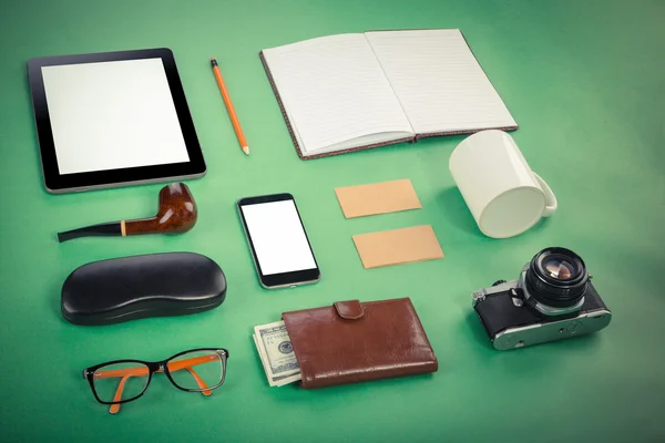 Set of Retro hipster mock up. Laptop, old camera, tablet and smoke pipe on green background. Filtered image