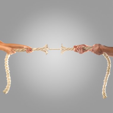 Hands of people pulling the rope on a gray background.  Competition concept clipart